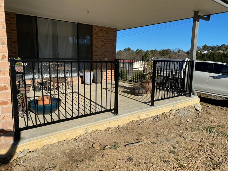 Black steel balustrade and gate around a raised residential verandah