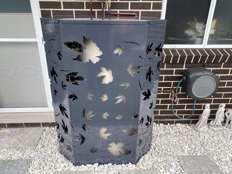 Laser-cut steel screen with leaf pattern wrapped around a rainwater tank